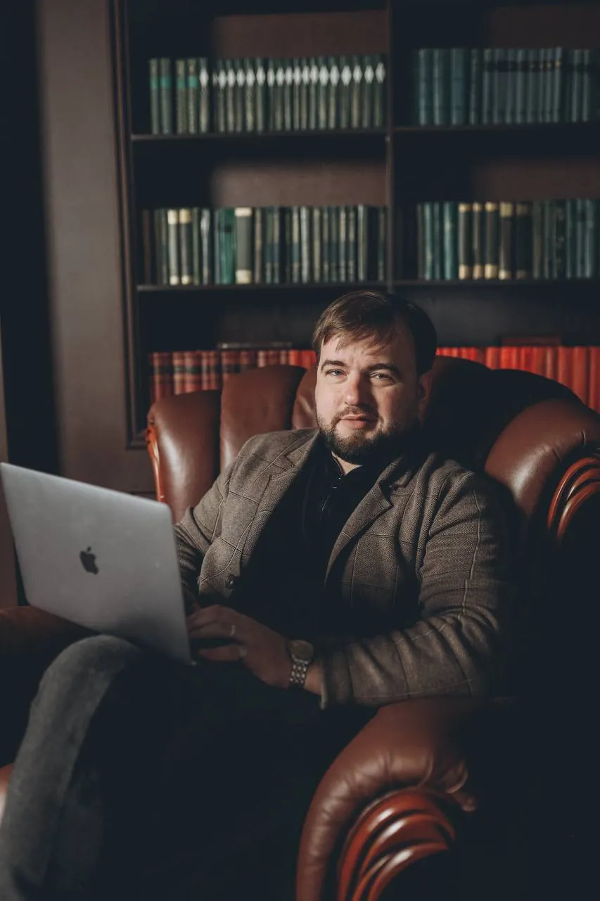Юрист Володин Кирилл Николаевич в рабочем кабинете на фоне книжных полок